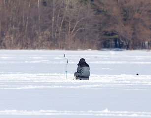 Fototapeta na wymiar A man on ice is fishing in the winter