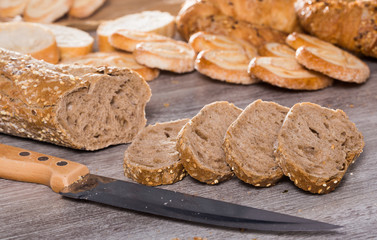 slices of wheaten bread and knife on wooden surface