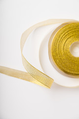 Coil of shiny golden ribbon  on white background. Backdrop for text or announcement