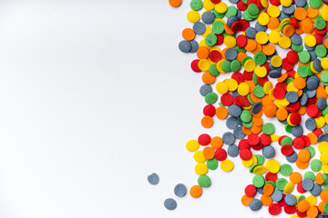 Colorful sweet confetti topping on white background with copy space at the left side