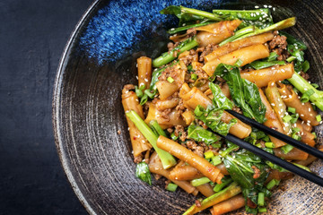 Thai Pad See Ew Noodles with vegetable and minced beef as close-up in a bowl with copy space