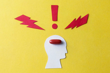 Cardboard image of the person who took the brain medicine from paper on a yellow background
