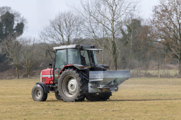Red tractor with automatic lime spreader