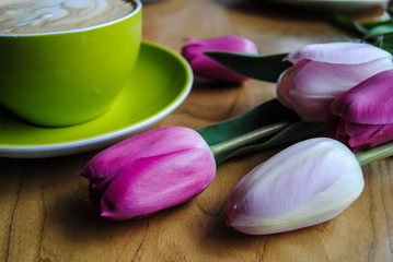 A cup of coffee and a bouquet of tulips