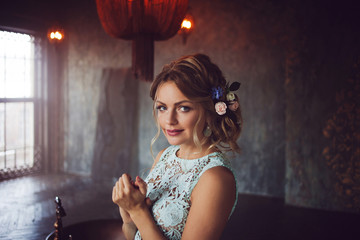 Young woman in lace dress and her hair decorated with flowers.