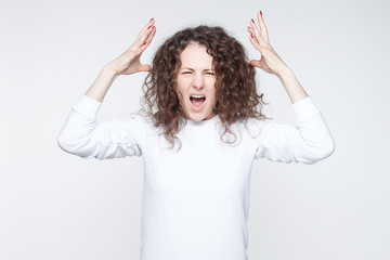 Young beautiful European young female clenches teeth in desperation, regrets about something,...