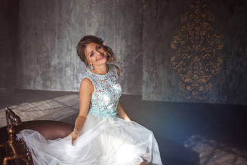 Fototapeta premium Smiling Young woman in lace dress and her hair decorated with flowers.