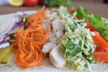 Homemade Shawarma with Chicken Meat fillet and Fresh Vegetables over Wooden Board. cooking Process.