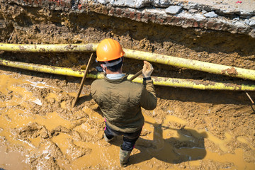 Worker working in ditch for sewage system in the city in Asia