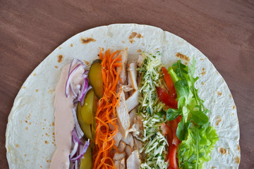 Homemade Shawarma with Chicken Meat fillet and Fresh Vegetables over Wooden Board. cooking Process.