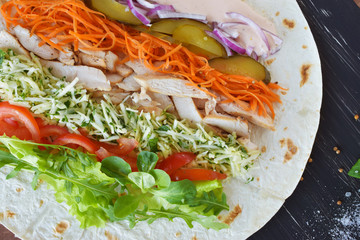 Homemade Shawarma with Chicken Meat fillet and Fresh Vegetables over Wooden Black Board. Cooking Proces.Healthy Food.