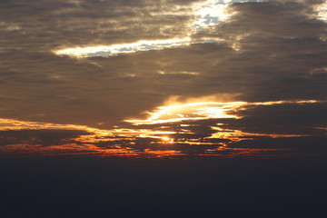 Orange sun light beam through the clouds when sunrise.