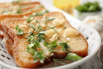 Plate with delicious homemade garlic bread, closeup