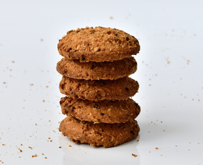 stack of oatmeal cookies on light background and crumbs