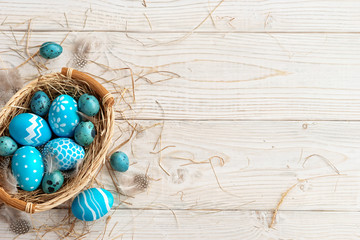 Easter background with Easter eggs and spring flowers. Top view with copy space.