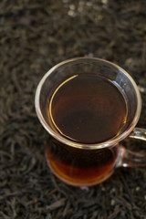 a few tea leaves on a blurred pile of dry tea leaves background, large leaf black Bayh tea front view, short focus. on white .