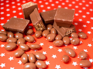 Pieces of chocolates on red background