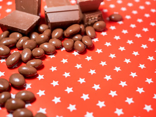 Pieces of chocolates on red background