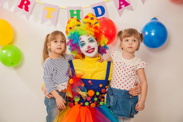 clown girl on the birthday of a child. Party for children. Clown with two little girls