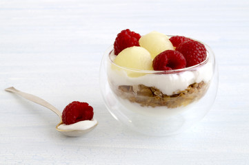 Homemade natural yogurt with melon and raspberry.