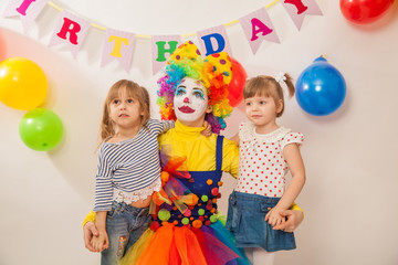 clown girl on the birthday of a child. Party for children. Clown with two little girls