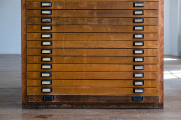 old vintage wooden cabinet with drawers with handles and plates, might have been used for large...