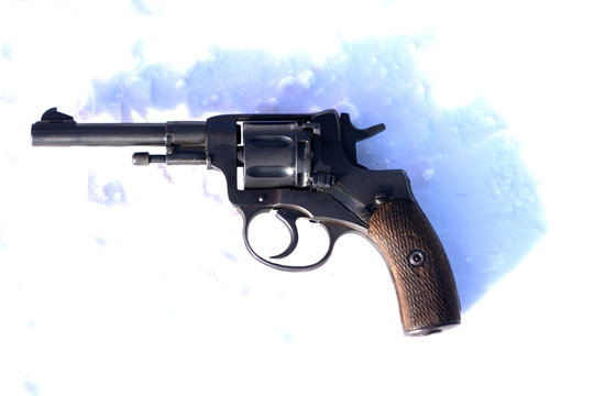 Mini Revolver with wooden grip on the blacket of snow .
