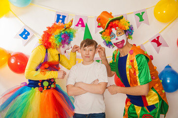 clown girl and clown boy at the birthday of a child. Party for children. Clowns try to cheer an adult boy
