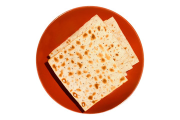 An overhead photo of Jewish Matzah bread on the ceramic plate isolated on white. Matzah for the Jewish Passover holidays. Selective soft focus. Place for text, copyspace.