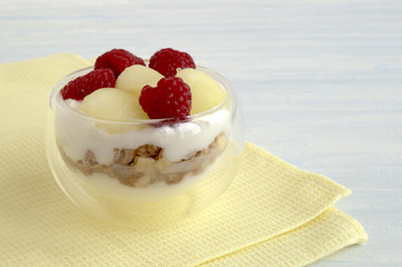 Homemade natural yogurt with melon and raspberry.