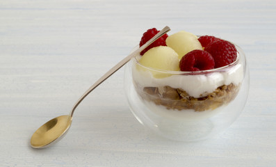 Homemade natural yogurt with melon and raspberry.