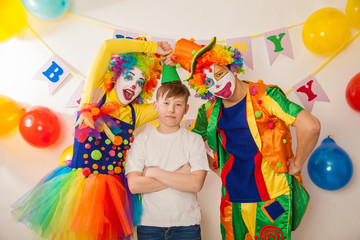 clown girl and clown boy at the birthday of a child. Party for children. Clowns try to cheer an adult boy