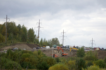 Man is working at the road construction next to an excavator .