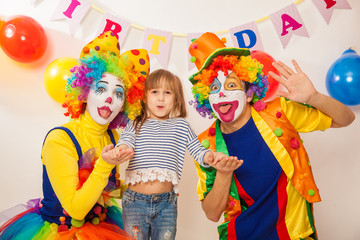 clown girl and clown boy at the birthday of a child. Party for children. Clowns and little girl show different emotions