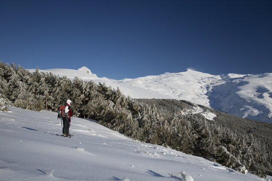 Mujer joven disffrutando de la nieve en la montaña