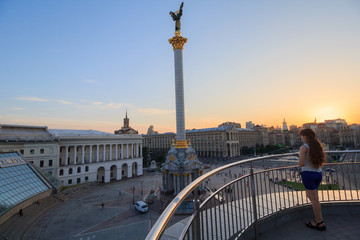 Girl from the terrace looks at the evening square of Independence. Kiev, Ukraine