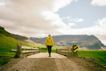 woman walking across a old wooden bridge in the countryside