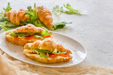 Croissants with soft cheese, salted salmon and green salad. Lovely healthy breakfast.