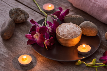 bath salt at bamboo bowl and orchids flowers on dark wood