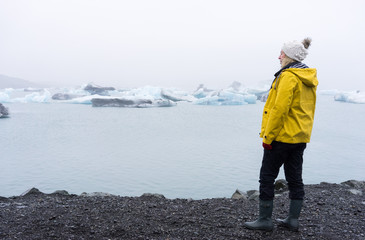 Woman looking out to icebergs in the sea