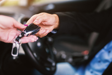Close up of mature professional elegant happy successful businessman is taking the keys while sitting inside the car after a successful car purchose.