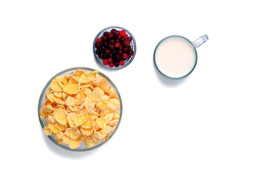 Bowls with cornflakes and cranberrries and cup with milk isolated on white. Flat lay.