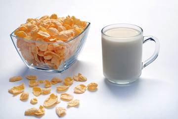 Bowl with cornflakes and cup with milk on light surface. Healthy food.
