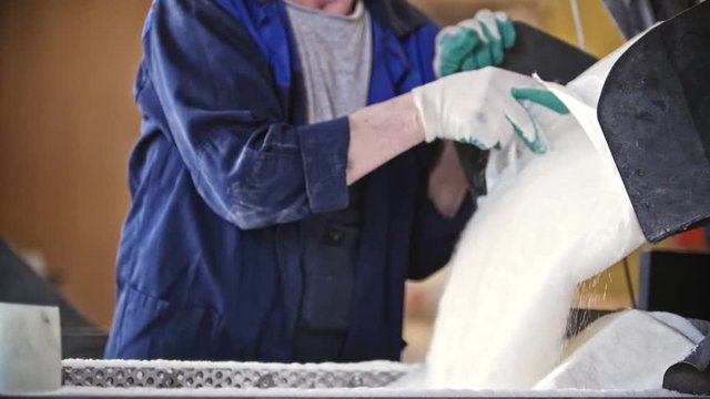 Worker dropping sugar on the production line at the sugar refinery