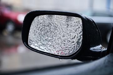 Vehicle mirror covered in ice during freezing rain
