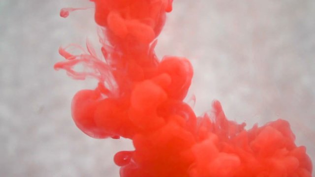 Red ink spilling into water