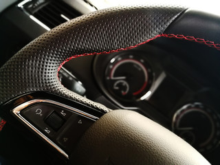 beautiful leather steering wheel on the background of a speedometer