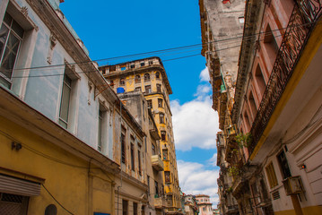 Traditional buildings in classic style with colorful facades on the background of blue sky with clouds. Havana. Cuba