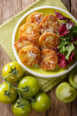 Delicious fried green tomatoes with fresh salad macro on a plate. Vertical top view