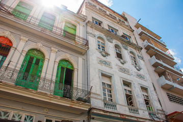 Traditional buildings in classic style with colorful facades on the background of blue sky with clouds. Havana. Cuba